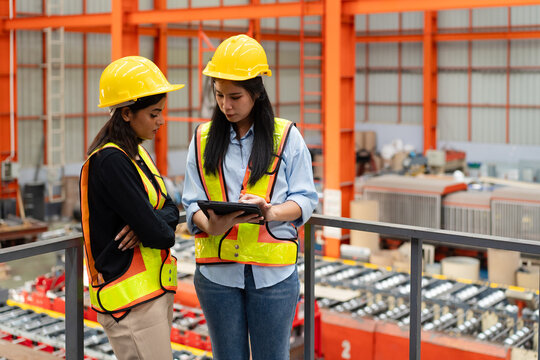 female engineer supervisor discuss with technician foreman use digital tablet to check production plan and timeline, team of diverse workers working together at industrial manufacturing factory