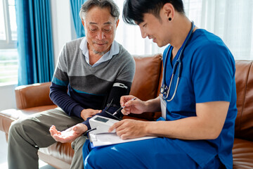 Obraz premium senior man using pulse oximeter to measure blood oxygen instructed by physiotherapist. home caregiver nurse visit retire couple for health check up recovery process medical service