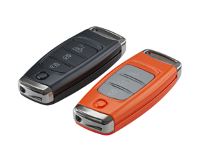 Two modern car keys, one black, one orange,  lying side-by-side.  Each key has a rectangular body, metal accents, and three buttons.  A  small hole or cutout is on one end of each key