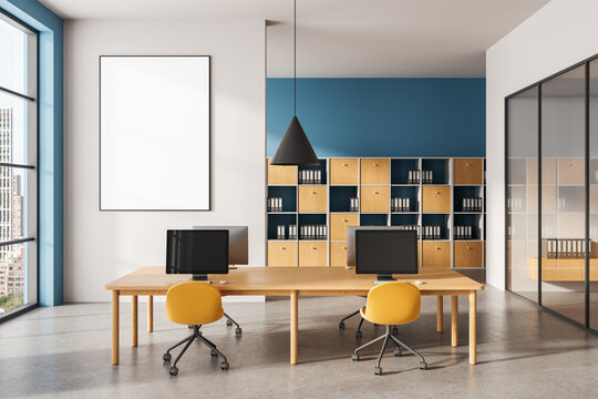 Modern office interior with blank vertical poster mockup on wall, wooden desks and yellow chairs in contemporary workspace setting. 3D Rendering