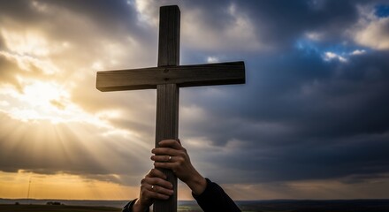 Hands holding wooden cross against a dramatic sky with sun rays, concept for faith illustration, religious symbol and christianity worship