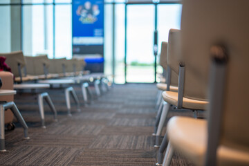 Airport lounges: The tranquil view of a waiting room with rows of clean chairs suggests anticipation, a potential meeting, or a quiet moment. A space of calm and anticipation.