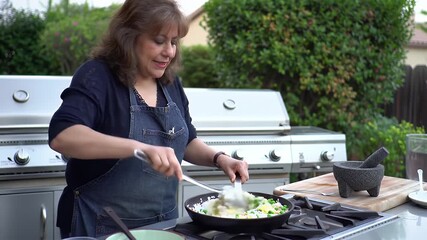 Enthusiastic Woman Stir Frying Rice with Egg and Peas in a Wok on a Stainless Steel Outdoor Grill Surrounded by Lush Greenery Displaying Her Culinary Prowess Creating a Vibrant and Appealing Scene
