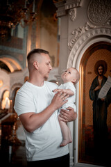 a father with a small child in a church or cathedral, the baptism of a baby in a church, the...
