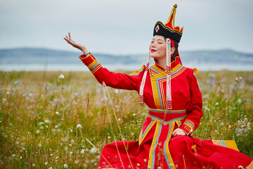 Mongolian girls dressed in luxurious Mongolian costumes on the grassland