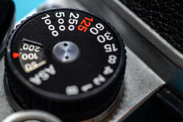 Close-up of a vintage camera shutter speed dial with numbers