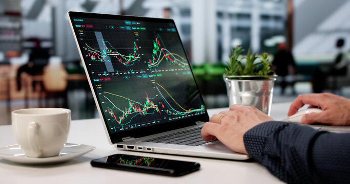 Man Managing Trades In Café On Laptop Screen - Powered by Adobe