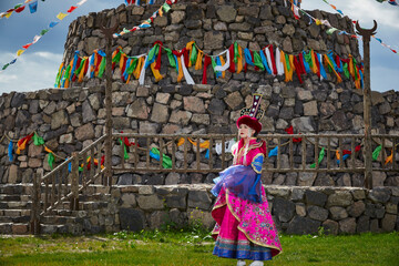 Naklejka premium Mongolian girls dressed in luxurious Mongolian costumes in front of an obo on the grassland