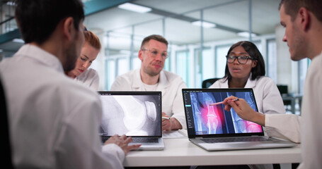 Radiologist Presenting X-ray On Laptop To Diverse Group
