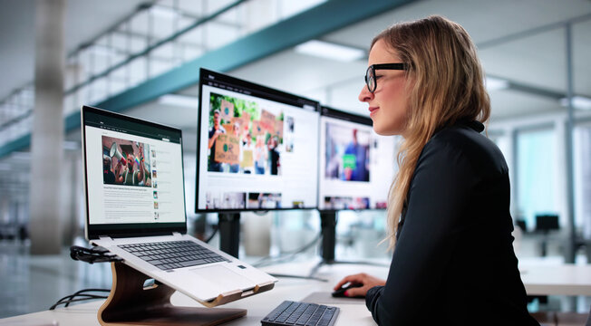 Young Female Journalist Writing News Article On Laptop