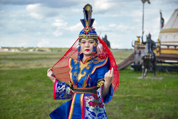 Mongolian girls dressed in luxurious Mongolian costumes on the Mongolian war chariots of the Jinyuan Grand Tent on the grassland