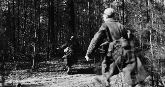 Historical Re-enactment Black And White Video. Men Dressed Like Russian Soviet Infantry Red Army Soldiers Of World War II Shooting machine gun from Forest entrenchment