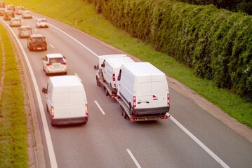 Highway Traffic In Blurred Motion with Cargo Van Transport on Car Carrier Trailer