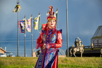 Mongolian girls dressed in luxurious Mongolian costumes in front of a yurt on the grassland