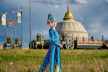 Mongolian girls dressed in luxurious Mongolian costumes in front of a yurt on the grassland