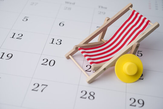 Red beach chair and hat on white blank calendar background copy space. Annual leave travel period for relaxation concept. Period of paid time off (PTO) granted to employees by their employer.
