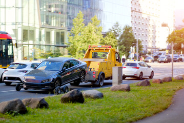 Yellow Tow Truck Pulling Broken Down Car in Busy City Traffic - Vehicle Evacuation