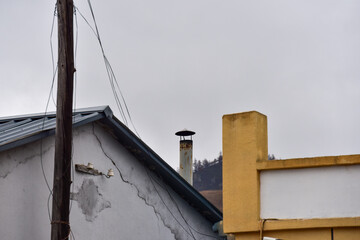 Buildings with a chimney and utility pole under an overcast sky