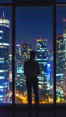 Obraz na płótnie Canvas Silhouette of a person looking at a night city view