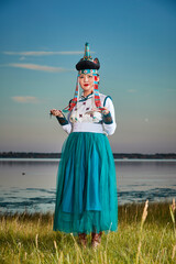 Obraz premium Young Mongolian sisters wearing traditional Mongolian clothing on the grassland