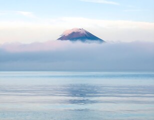 A serene, symmetrical mountain peak is partially obscured by soft clouds and mist, rising from a calm body of water in a dreamlike, tranquil scene.