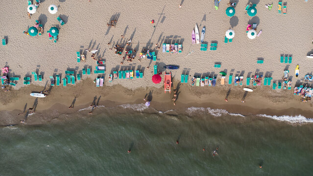 Vista zenitale di spiaggia attrezzata con ombrelloni e lettini, vista aerea