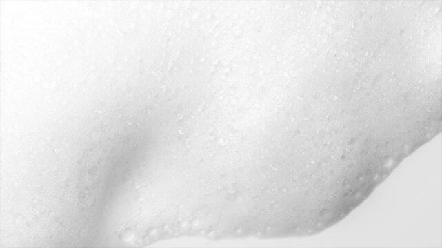 Foam bubbles background. Moving Soap foam popping bubble, white backdrop. Soap sud macro structure. Soap foam close-up. Clean, cleaning concept, laundry, shower concept 