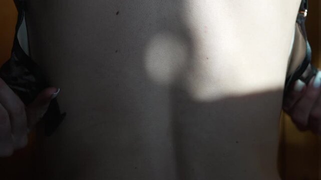 Hands bra lingerie, woman fastening and unfastening black delicate undergarment.