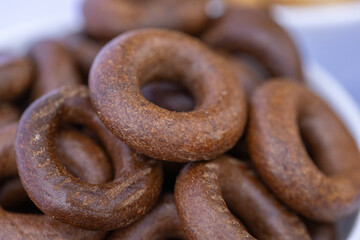 Freshly baked mini bagels on a dark background. Top view. Pretzels in the form of a ring close-up. Small bread circle biscuit. Bowls with different types of bagels.

