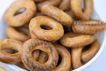 Freshly baked mini bagels on a dark background. Top view. Pretzels in the form of a ring close-up. Small bread circle biscuit. Bowls with different types of bagels.
