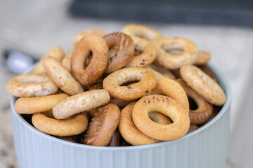 Freshly baked mini bagels on a dark background. Top view. Pretzels in the form of a ring close-up. Small bread circle biscuit. Bowls with different types of bagels.
