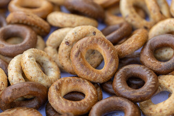 Freshly baked mini bagels on a dark background. Top view. Pretzels in the form of a ring close-up. Small bread circle biscuit. Bowls with different types of bagels.
