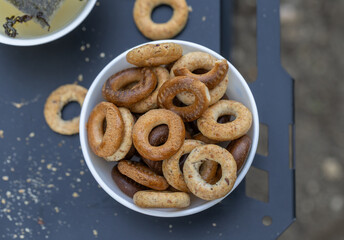 Freshly baked mini bagels on a dark background. Top view. Pretzels in the form of a ring close-up. Small bread circle biscuit. Bowls with different types of bagels.

