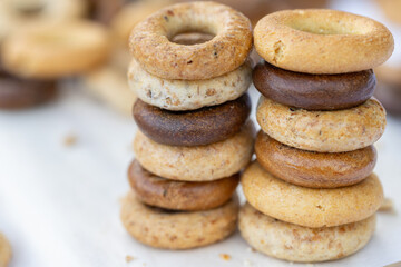 Freshly baked mini bagels on a dark background. Top view. Pretzels in the form of a ring close-up. Small bread circle biscuit. Bowls with different types of bagels.
