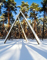 Snow-covered forest with triangular wooden structures