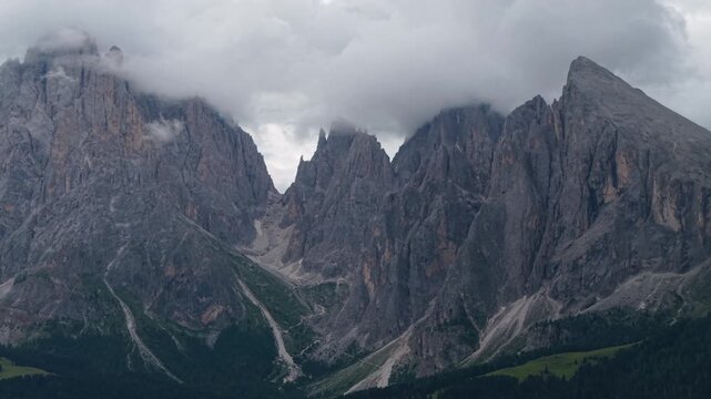 Clouds embracing the Dolomites peaks in Alpe di Suisi, Italy