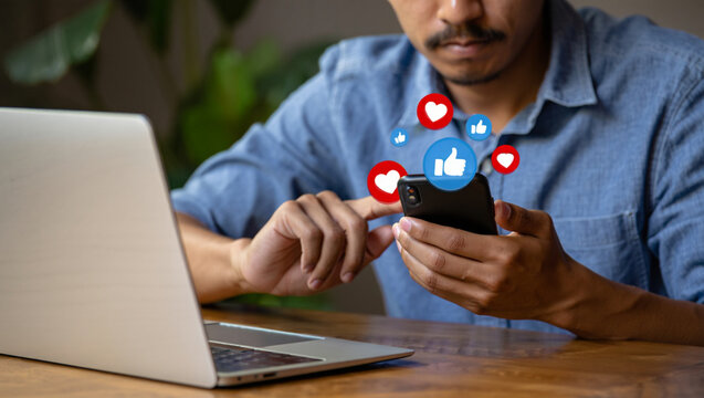 Person using smartphone with social media likes and hearts floating above mobile technology - Powered by Adobe