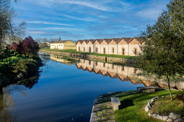Obraz premium Old warehouses reflected in the Canal de Castilla in the city of Alar del Rey.