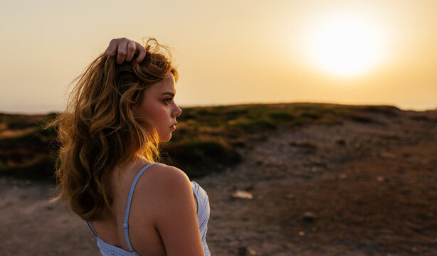 Woman in profile at sunset with thoughtful expression