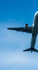 Low-angle view of airplane underside against clear blue sky, showcasing travel, freedom, and journey concepts