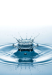 Close up of a water splash crown forming on a calm blue surface