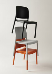 Stack of three modern chairs in different colors on a light background