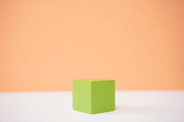 Obraz premium Green wooden cube on a gradient background ideal for educational or abstract concept visualizations