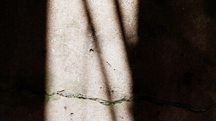 Abstract texture background of cracked concrete floor with dramatic light and shadow contrast...
