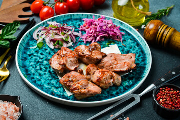 Grilled turkey meat kebabs. On a plate, served with fresh vegetables. Top view.