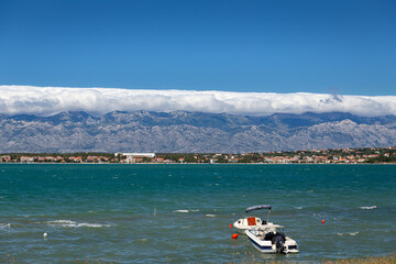 landscape with a boat in a bay and mountains in the background © talavietis