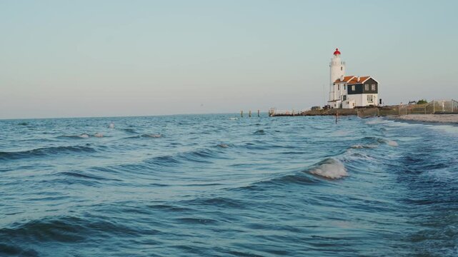 Picturesque Lighthouse on Dutch Peninsula Marken by sunset