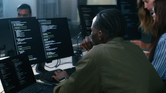 Professional African American male Software Engineer Pointing to desktop computer screen monitor checking line code, examining, planning to development application in Co working Office Space.