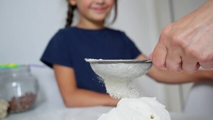 Capturing the exquisite art of baking with precision, carefully sifting flour onto dough for making delicious treats. Slow motion