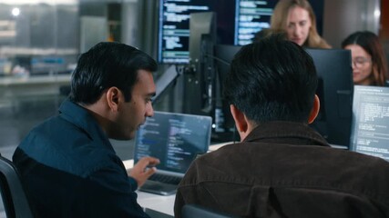 Two Software Developer, Programmer discussing, explaining to colleague working on code, application software development project using desktop computer, work together in co-working office space. - Powered by Adobe